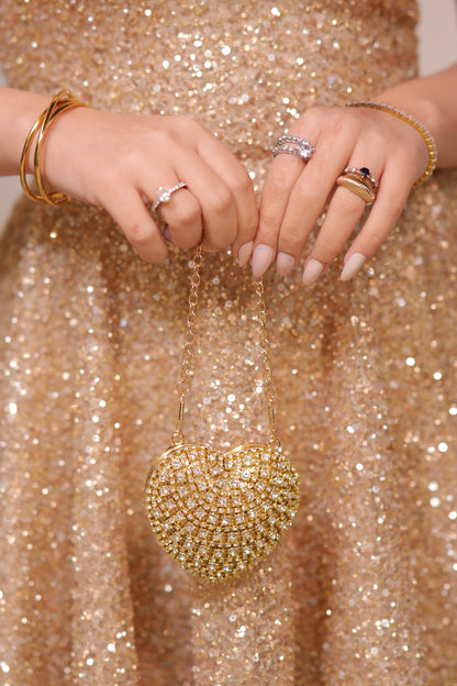 Sam Heart Bag by Imagine By Shiwali in golden color, featuring a heart-shaped design with a sleek, stylish appearance.