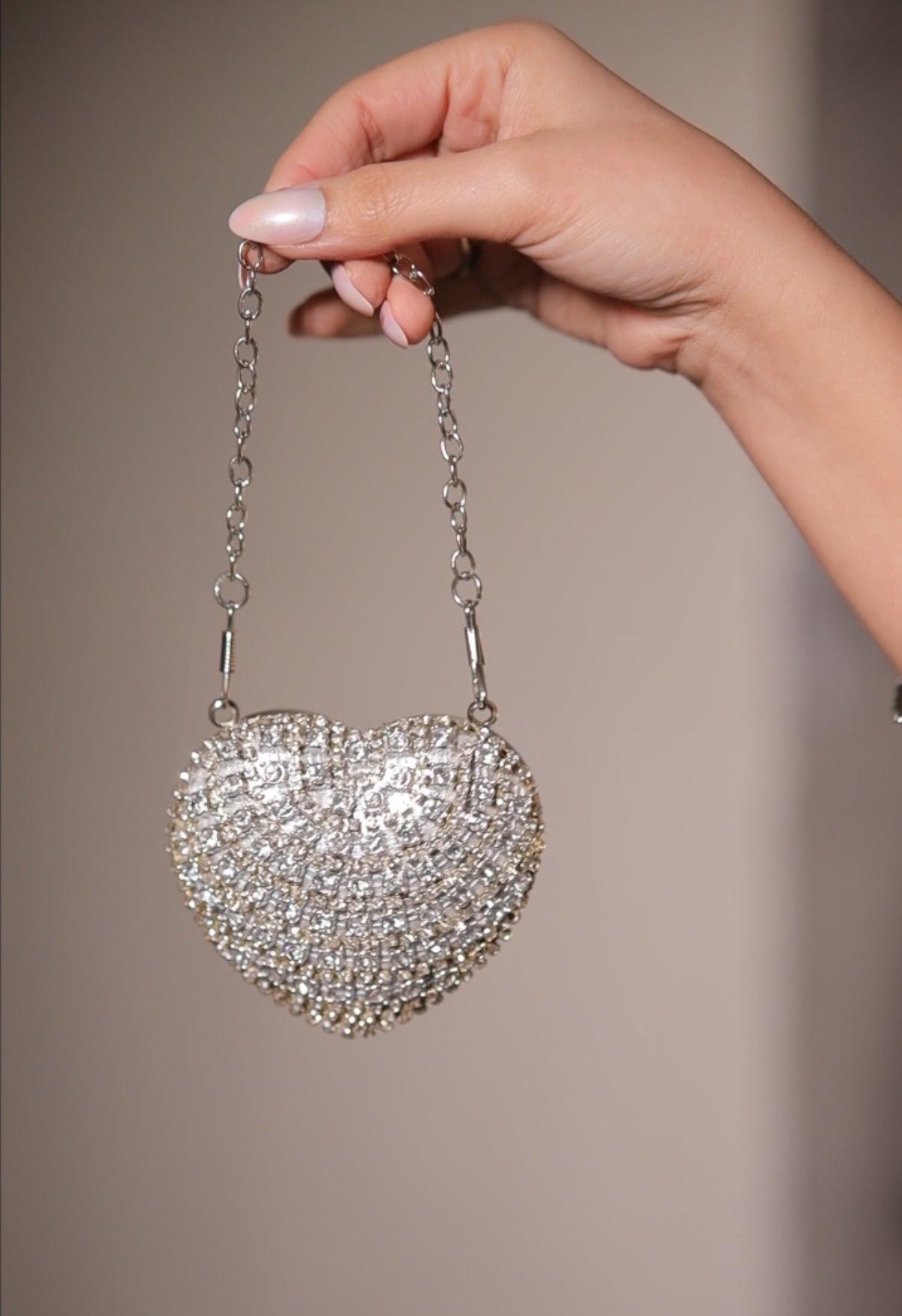 Silver Sam Heart Bag by Imagine By Shiwali, showcasing a stylish heart-shaped handbag with metallic finish and elegant design.