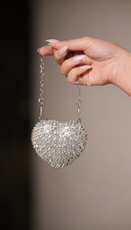 Silver Sam Heart Bag by Imagine By Shiwali featuring a compact heart-shaped design with a chain strap and metallic finish.