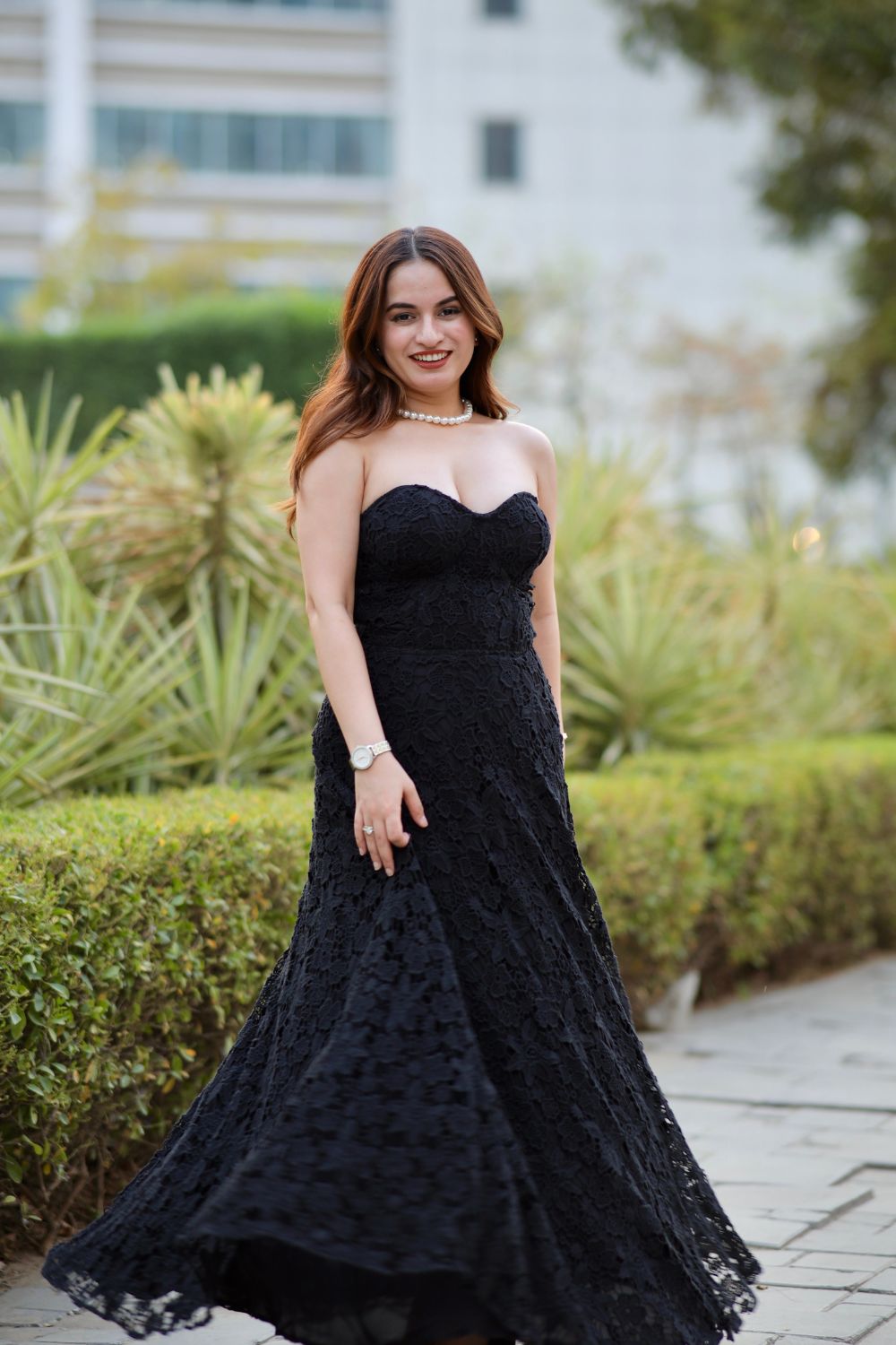 Black Bella dress by Imagine By Shiwali, displayed on a hanger with a close-up of the fabric and stylish design.