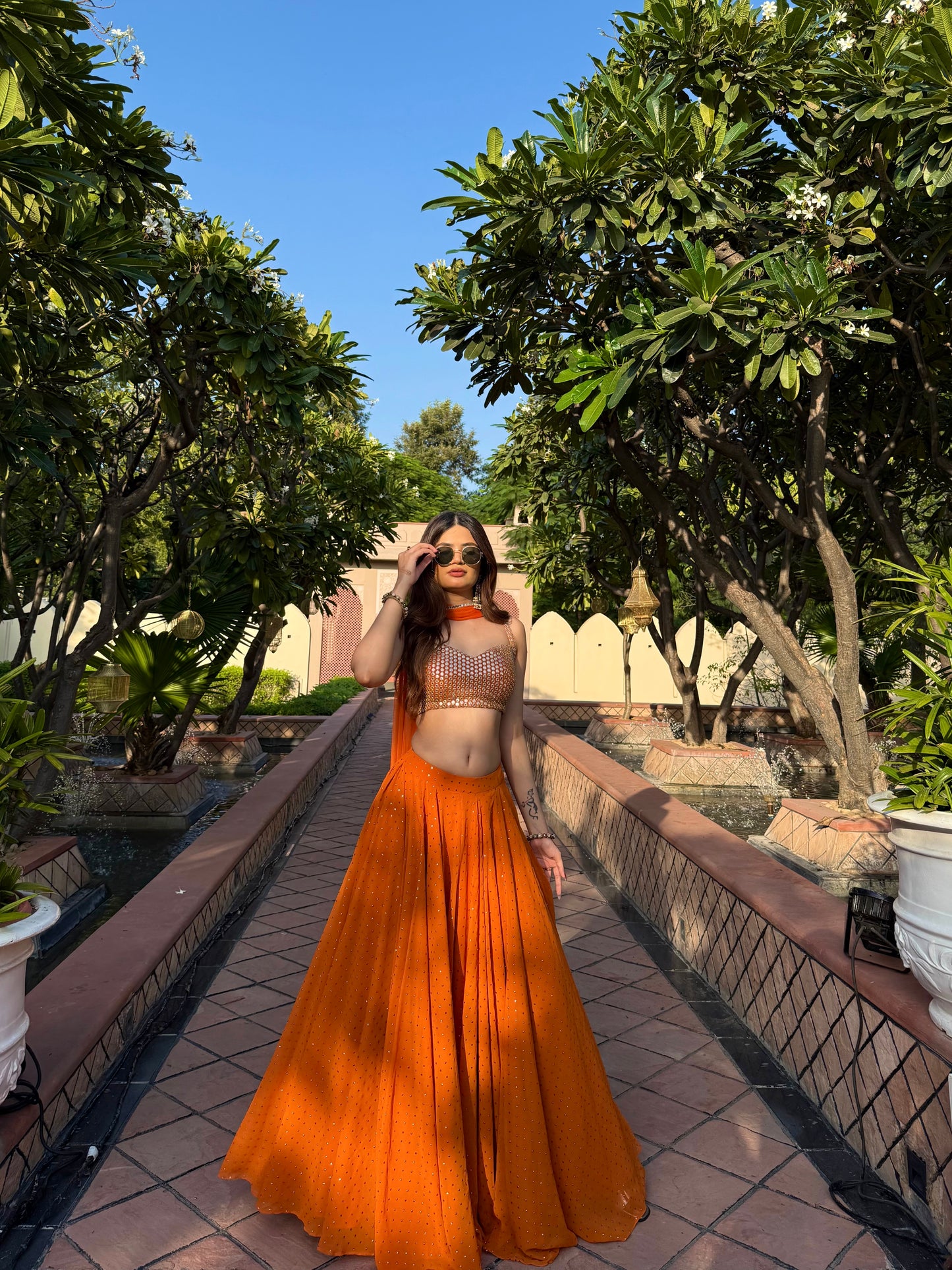 Bright orange Chameli Lehnga by Imagine By Shiwali featuring intricate embroidery and traditional design.