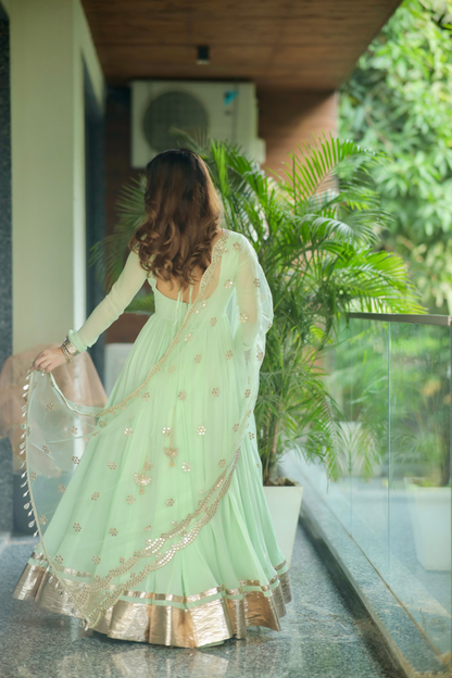 Imagine by Shiwali Morni green anarkali dress with intricate embroidery and flowing fabric, displayed on a hanger.