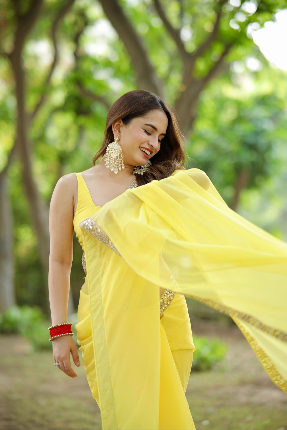 Yellow Raveena Georgette saree with matching blouse, featuring intricate traditional designs and elegant draping.