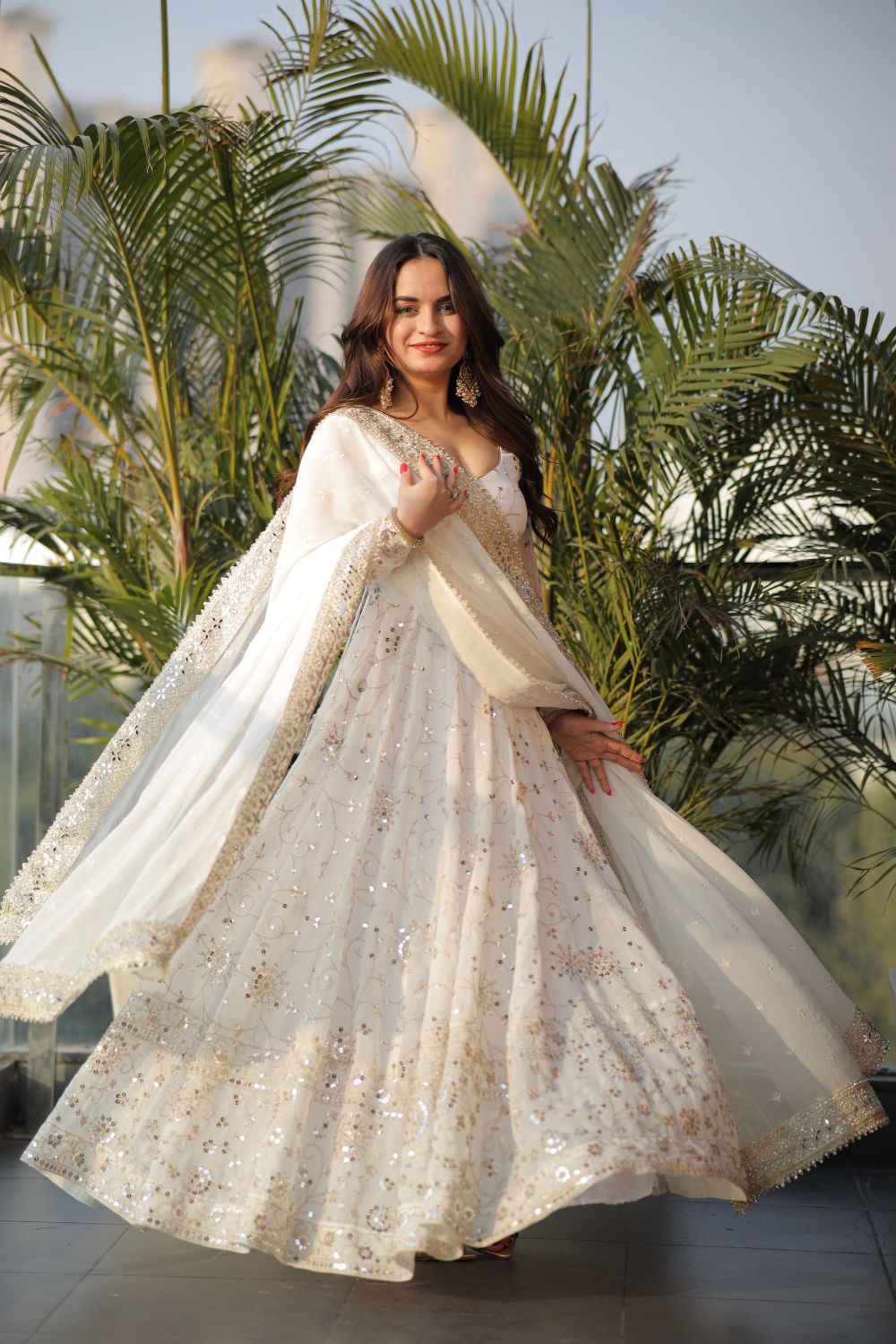 White embellished Maastani Anarkali dress by Imagine By Shiwali featuring intricate embroidery and flowing fabric.