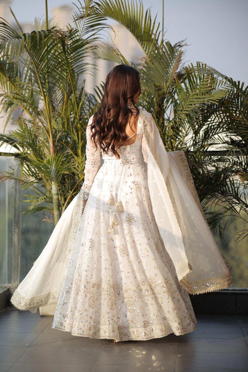 White embellished Maastani Anarkali dress by Imagine By Shiwali, featuring intricate embroidery and flowing fabric.