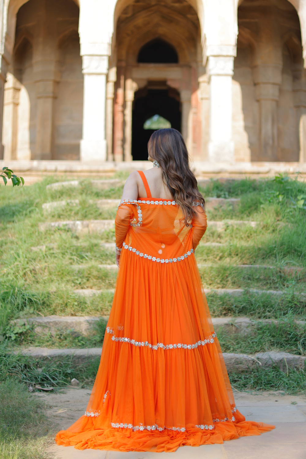 Vridhi Sunset Radiance orange lehenga set by Imagine by Shiwali with embroidered cape, featuring intricate detailing and vibrant fabric.