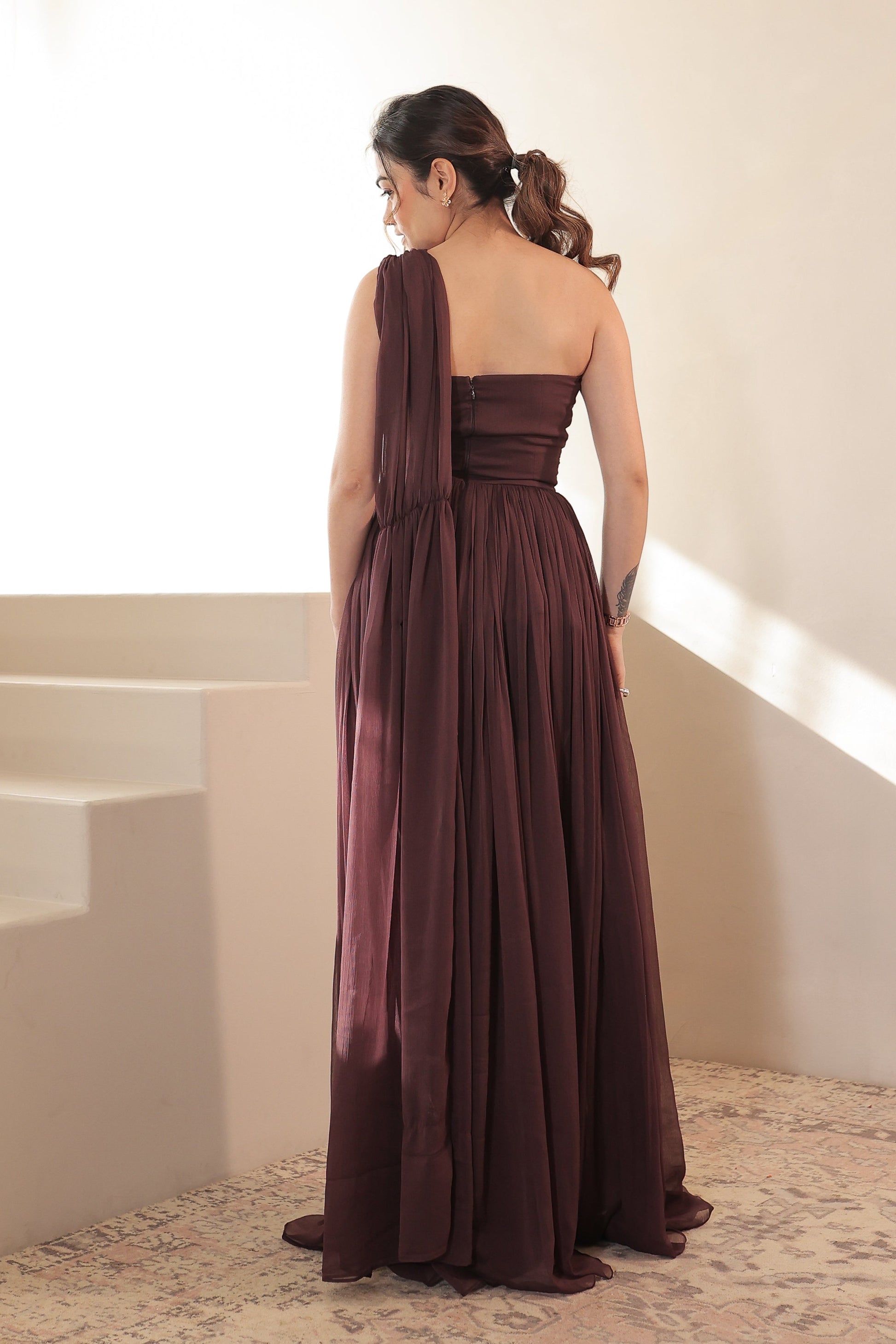 Imagine by Shiwali Britney brown gown displayed on a hanger, featuring elegant fabric and detailed design.