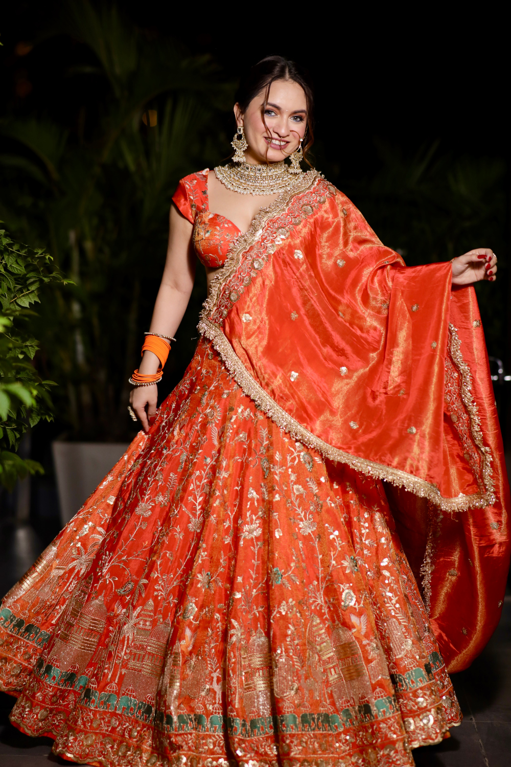 Chandani orange lehnga with intricate zari work from Imagine By Shiwali, showcasing detailed embroidery and vibrant fabric.