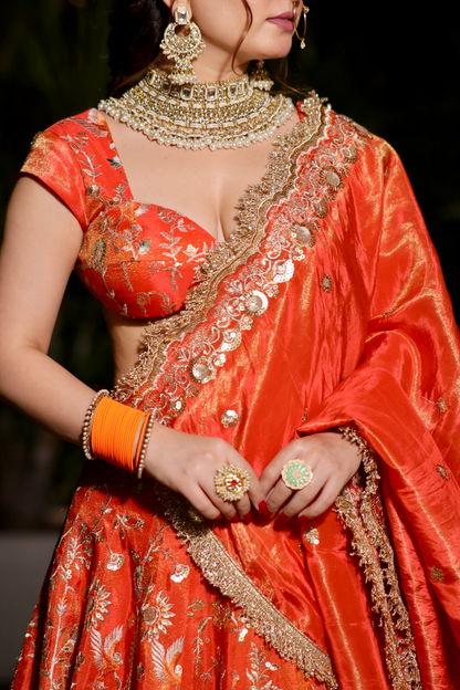 Chandani orange lehnga with intricate zari work by Imagine By Shiwali, featuring traditional embroidery and vibrant fabric.