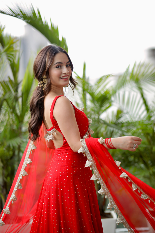 Red Dolly Anarkali dress by Imagine By Shiwali featuring intricate embroidery and flowing fabric.