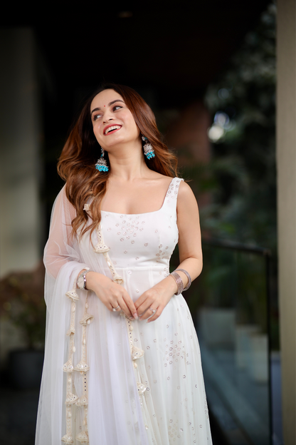 White Dolly Anarkali dress by Imagine By Shiwali, featuring intricate embroidery and flowing fabric, displayed on a mannequin.