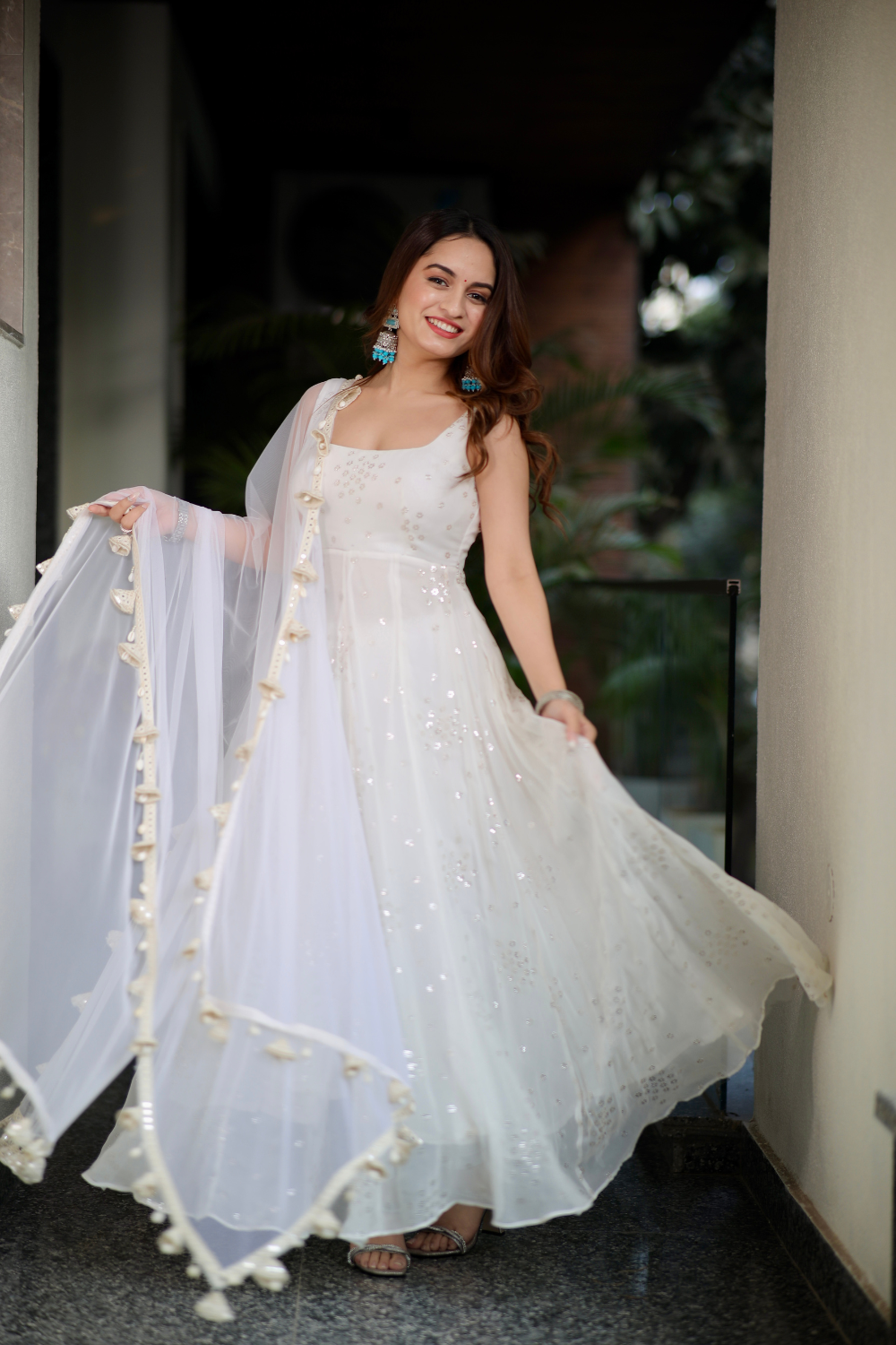 White Dolly Anarkali dress by Imagine By Shiwali, featuring intricate embroidery and flowing fabric, worn by a model.