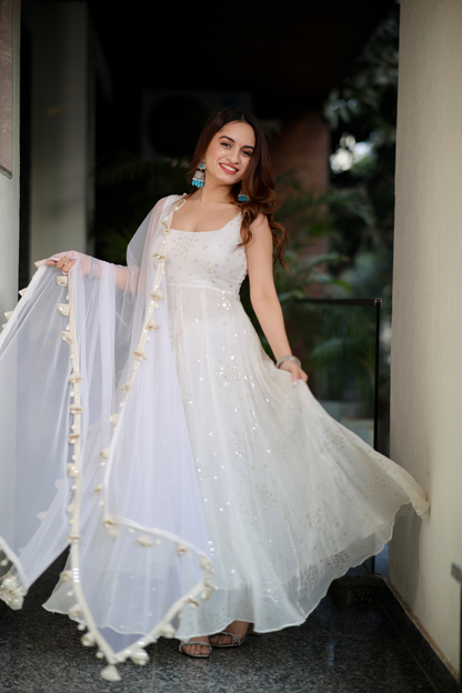 White Dolly Anarkali dress by Imagine By Shiwali, featuring intricate embroidery and flowing fabric in a traditional style.