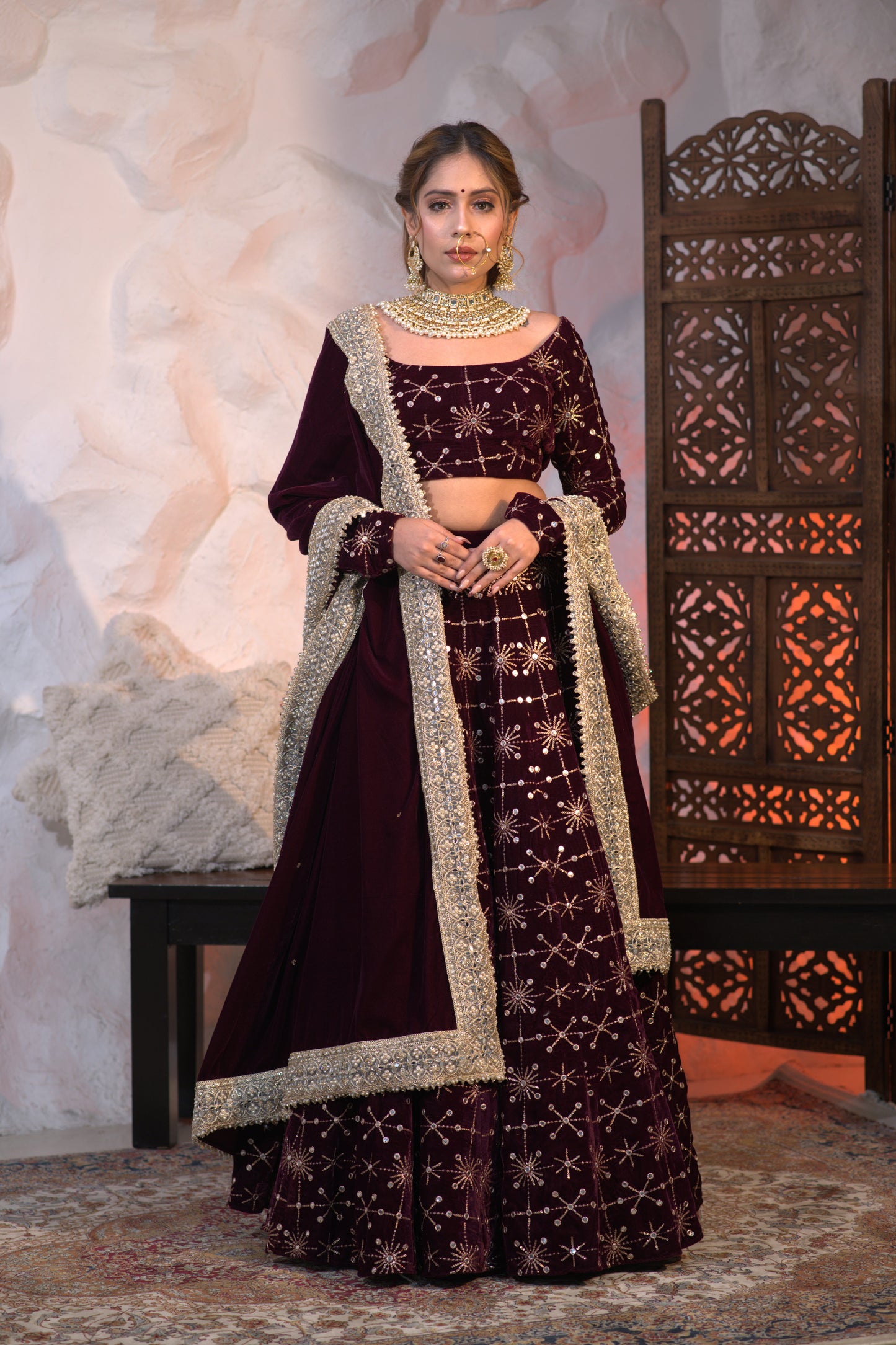 Wine-colored Geetanjali velvet lehnga by Imagine By Shiwali featuring intricate embroidery and flowing fabric.
