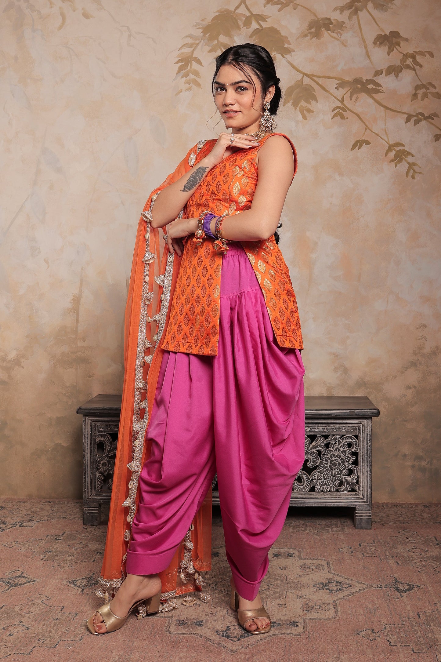 Imagine By Shiwali Kavya dhoti set in vibrant orange and purple, featuring traditional Indian attire with intricate designs.