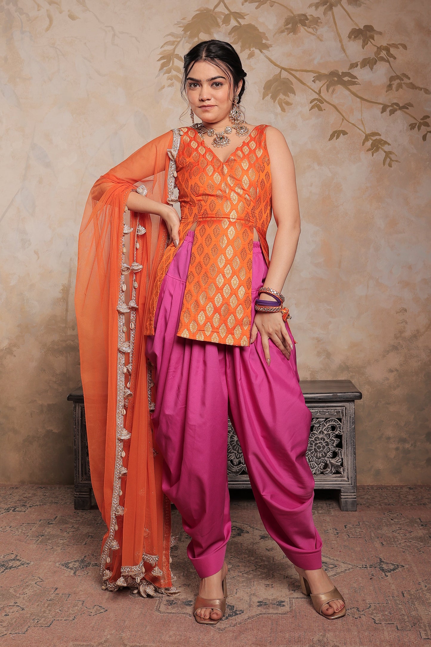 Imagine By Shiwali Kavya dhoti set in vibrant orange and purple, featuring traditional styling and intricate fabric details.