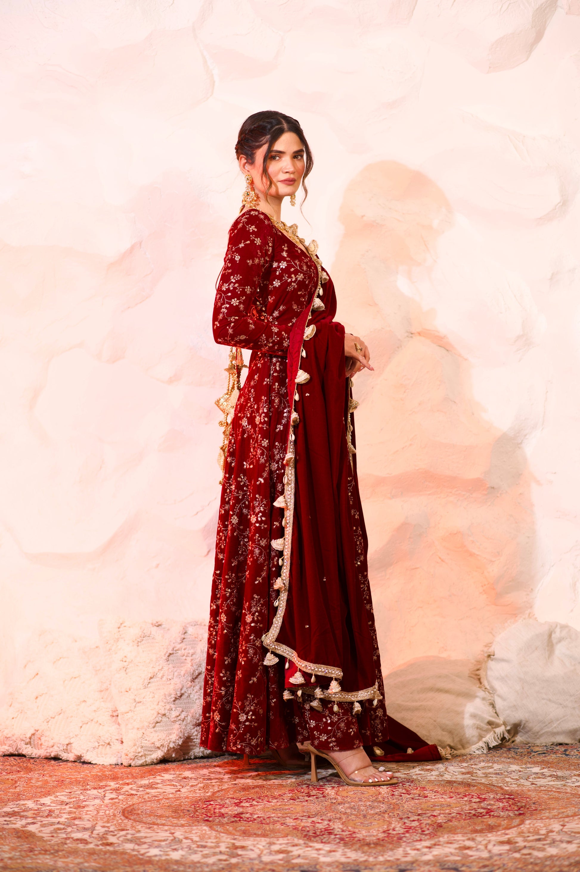 Red velvet Malaika Anarkali suit by Imagine By Shiwali with intricate embroidery and flowing fabric, showcased on a mannequin.
