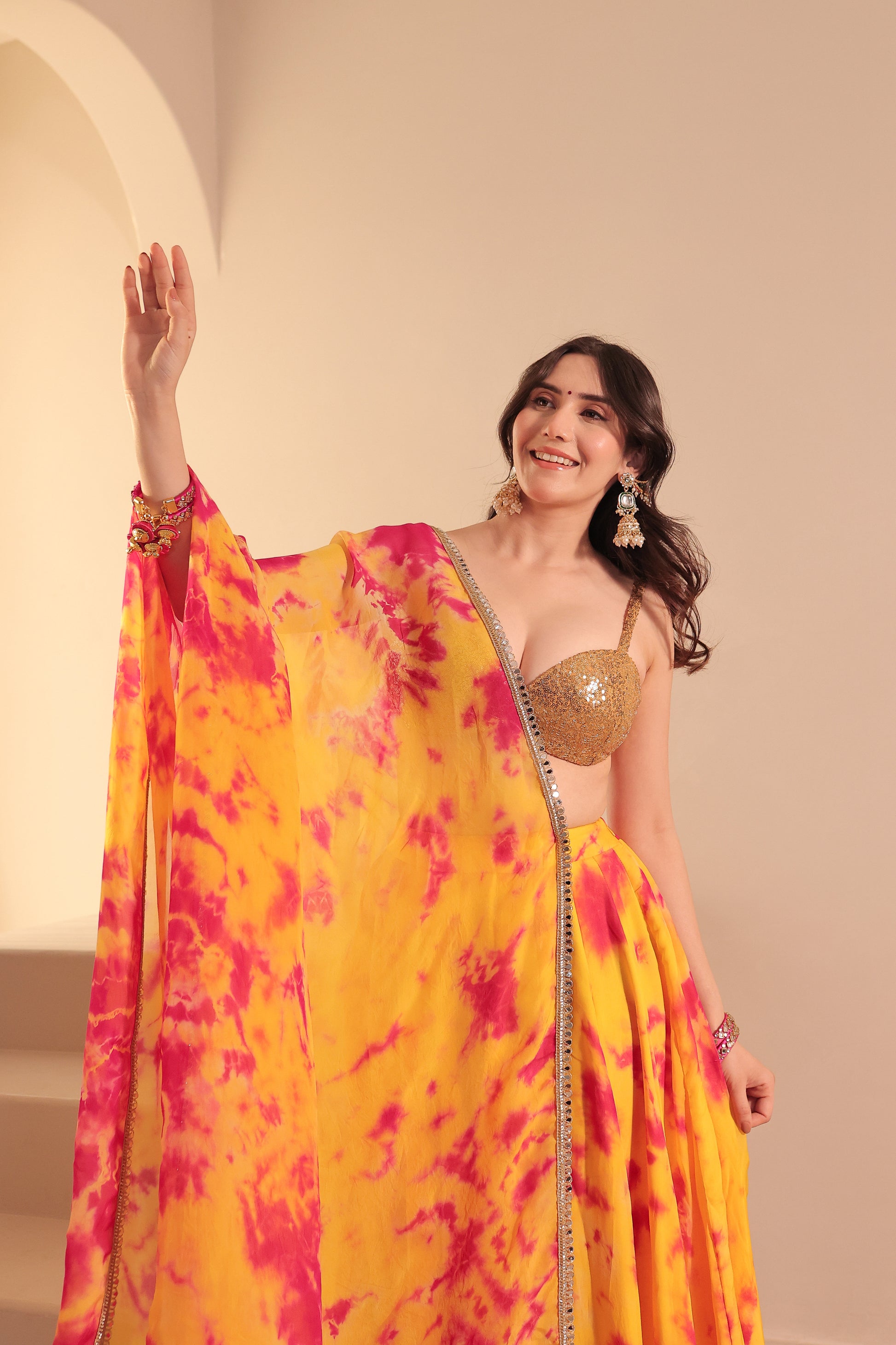 Yellow and red tie-dye lehenga set by Imagine By Shiwali featuring traditional embroidery and flowy fabric.