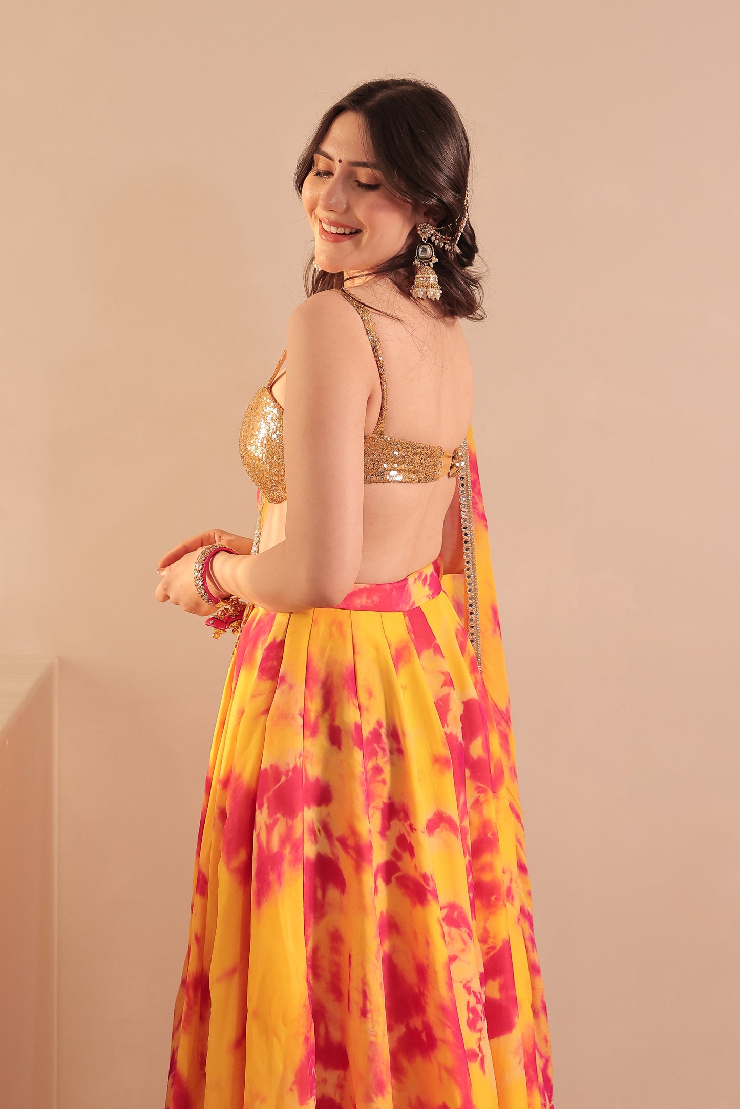 Yellow and red tie-dye lehenga set by Imagine By Shiwali featuring intricate designs and traditional styling.