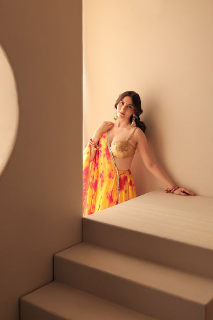 Yellow and red tie-dye lehenga set from Imagine By Shiwali featuring traditional design and vibrant fabric details.