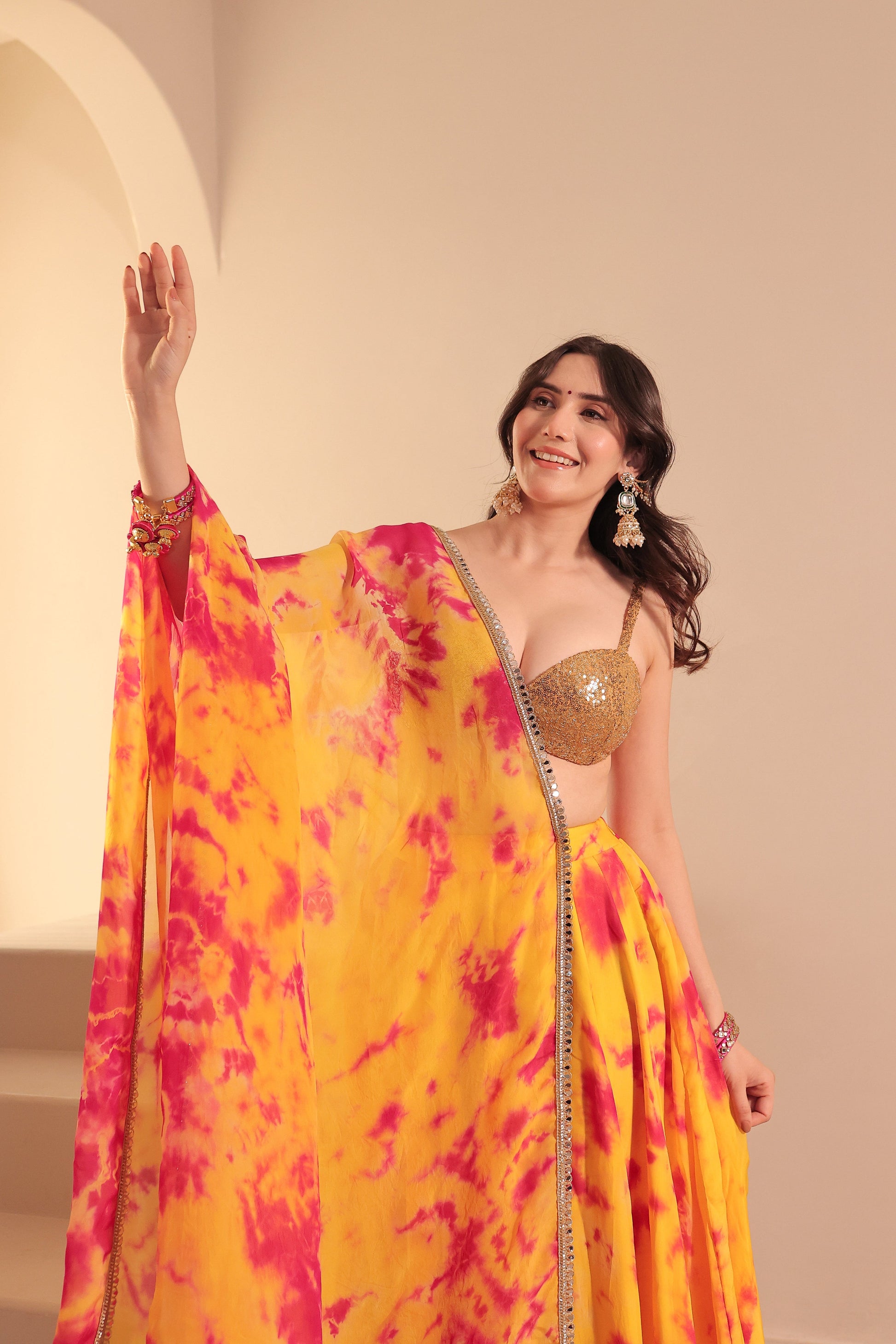 Yellow and red tie-dye lehenga set by Imagine By Shiwali, featuring traditional embroidery and vibrant fabric.